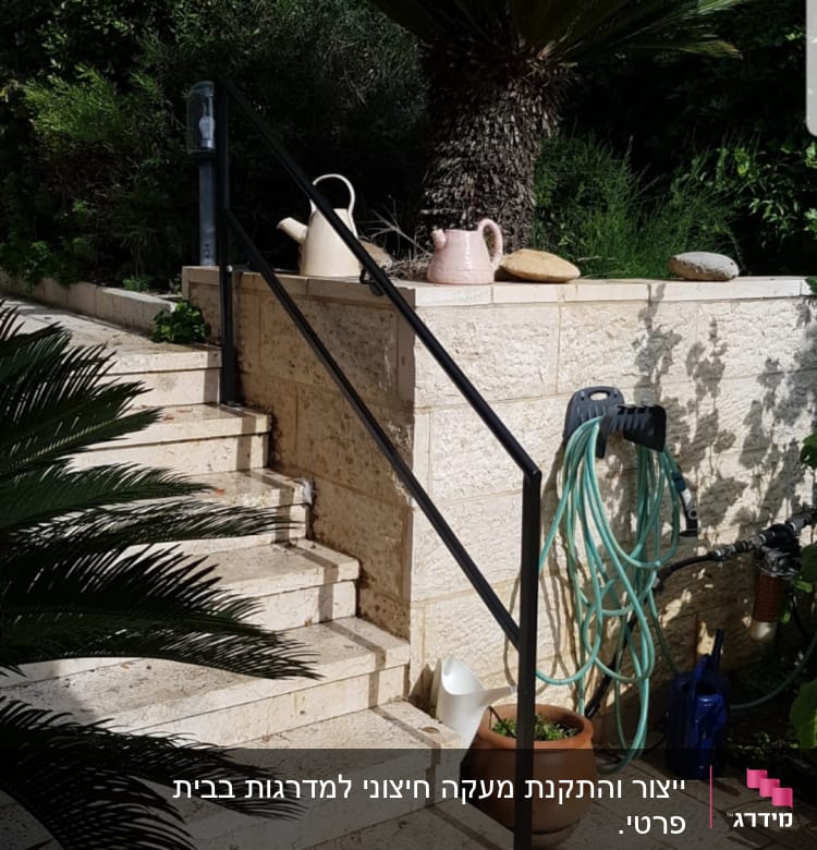 מדרגות אבן עם מעקה מתכת וצינור מים ירוק
